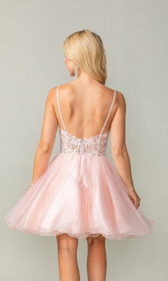 Woman showing the back of a pink dress she's wearing in front of a plain background