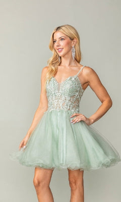 Woman wearing a light green dress with lace details on a plain background