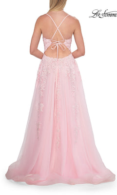 A woman seen from behind wearing a light pink, floor-length Floral Lace Embroidered Prom Dress: La Femme 33715, featuring floral appliqué details and a crisscross open back.