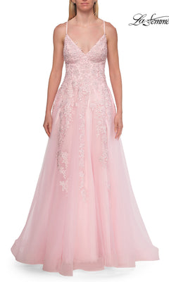 A woman is wearing the Floral Lace Embroidered Prom Dress: La Femme 33715, a floor-length, light pink gown featuring floral lace appliqué details, thin straps, and a fitted bodice. The image has a white background with the La Femme logo in the top right corner.