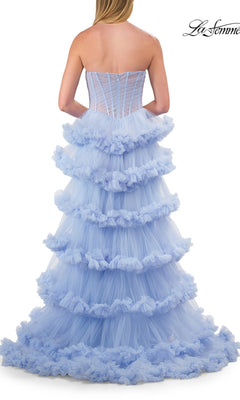 A woman wearing the Strapless Tiered Prom Ball Gown: La Femme 33717—a strapless, light blue dress featuring ruffled layers of tiered tulle—is photographed from the back against a white background.