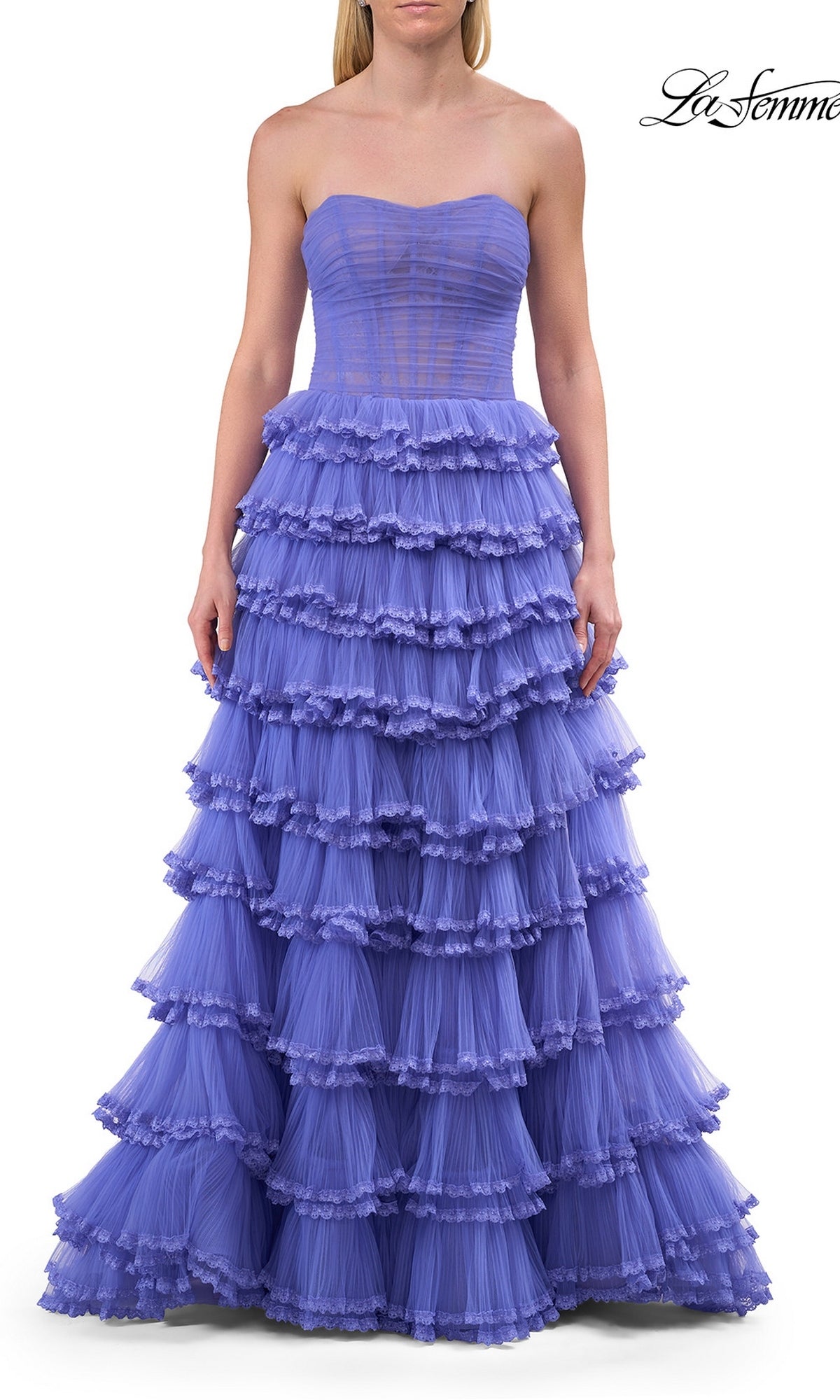 A woman wears the Long Prom Dress: La Femme 33727, a strapless lavender tiered tulle ball gown with a fitted corset bodice and a full layered skirt. The background is white.