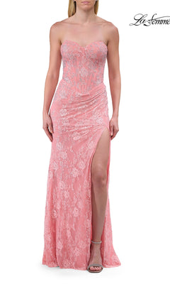 A woman wearing the Strapless Long Lace Prom Dress: La Femme 33768, a floor-length peach gown featuring delicate floral lace detailing and a thigh-high slit, stands against a white background.