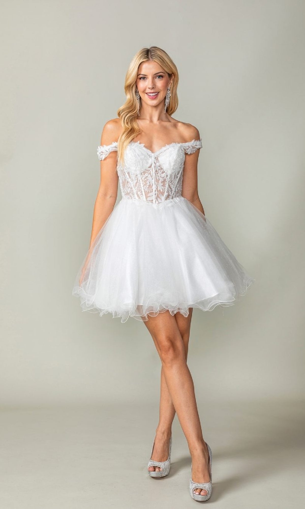 Woman wearing a white short poofy dress against a plain background