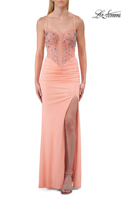 A woman wearing the Sheer-Corset Long Prom Dress by La Femme (style 33783) in peach, featuring thin straps, a floor-length skirt with a high slit, and floral embroidery on the bodice.