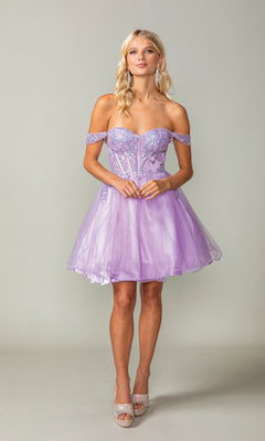 A woman poses in the Dancing Queen 3383 short corset homecoming dress, featuring floral embellishments and a sparkly sheer bodice, styled with high heels against a plain background.