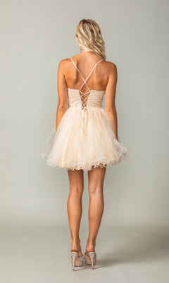 A woman faces away, wearing the Lace-Up Short Babydoll Homecoming Dress 3385—a light beige, sleeveless cocktail dress with crisscross straps and lace-up back—paired with high heels.
