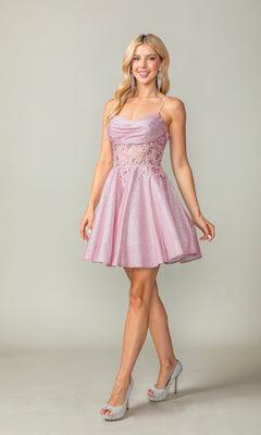 A woman poses in a studio wearing the Cowl-Neck Short Glitter Homecoming Dress 3386 in light pink, with sparkly fabric, spaghetti straps, lace accents, and paired with high heels.