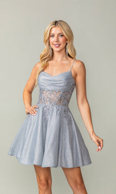 A woman wears the Cowl-Neck Short Glitter Homecoming Dress 3386, a light blue party dress with a cowl neck, spaghetti straps, glittery fabric, and flared skirt, standing against a plain background.