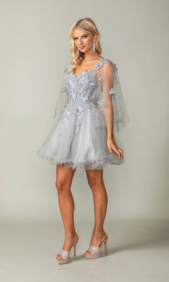 A woman wears the Butterfly-Cape Short A-Line Homecoming Dress 3393 in light gray tulle with floral and sequin appliques, sheer butterfly capelet sleeves, paired with sparkly high-heeled shoes.