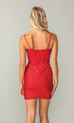 A woman with blonde wavy hair models the Cowl-Neck Short Glitter Homecoming Dress 3396, a fitted, sleeveless red dress, shown from the back against a plain background.