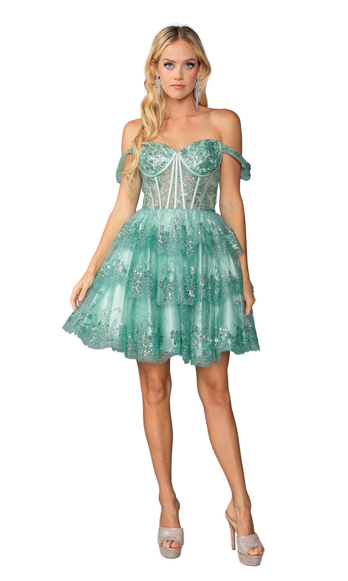 A woman wears the Short Ruffled Hoco Dress: Dancing Queen 3400—a green, off-the-shoulder mini dress with layers, a fitted bodice, and glitter accents—styled with open-toe heels. Perfect as a chic sequin cocktail or party look.