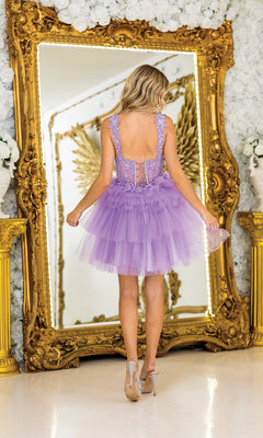A woman wearing the Dancing Queen 3402 Short Babydoll Prom Dress stands before a large ornate gold mirror, its reflection framing her with ethereal angel wings.