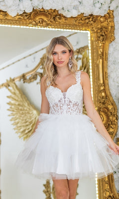 A woman in the Dancing Queen 3402 short babydoll prom dress stands before a gold ornate mirror and decorative gold angel wings.