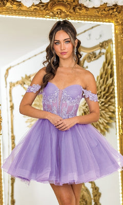 A woman wearing the Fit-and-Flare Glitter Hoco Dress: Dancing Queen 3410—a short, off-the-shoulder lavender tulle dress with a sheer corset bodice and lace details—stands before an ornate gold-framed mirror.