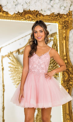 A woman in the Short Glitter-Tulle Prom Dress: Dancing Queen 3413 stands before a gold ornate mirror and white floral arrangement, smiling at the camera.