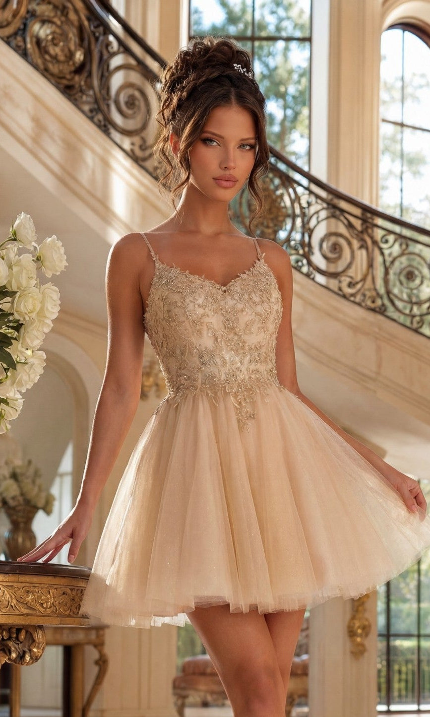 A young woman in a Short Glitter-Tulle Prom Dress: Dancing Queen 3413 in champagne stands indoors near a staircase, posing with one hand on a table and the other holding her sparkling dress.