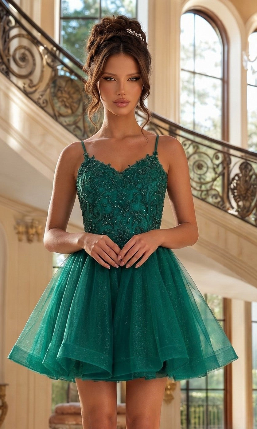 A woman stands indoors in the Dancing Queen 3413 short glitter-tulle prom dress in hunter green, featuring a fitted beaded bodice and tulle skirt. Ornate stair railings and large windows are seen behind her.