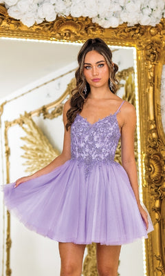 A young woman wearing the Short Glitter-Tulle Prom Dress: Dancing Queen 3413 poses in front of an ornate gold mirror, holding out her skirt.