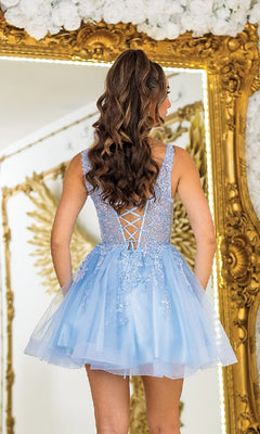 A woman in the Lace-Up Short A-Line Prom Dress: Dancing Queen 3414 stands before an ornate gold-framed mirror decorated with floral and wing accents.