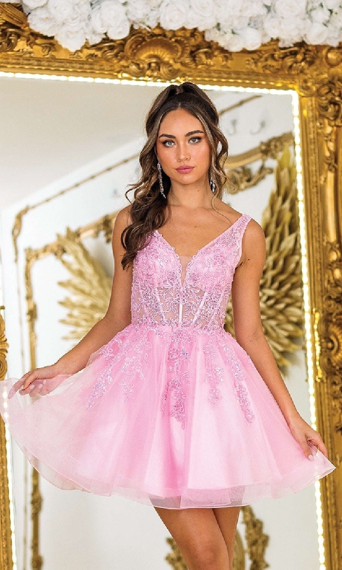 A woman in the Dancing Queen 3414 Lace-Up Short A-Line Prom Dress stands before a large ornate mirror with gold-trimmed floral decorations.