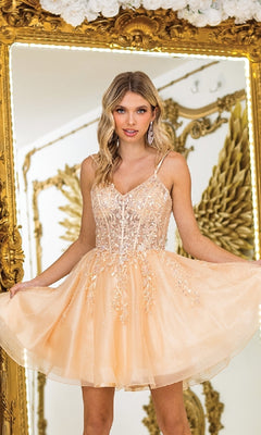 A woman poses in front of a large ornate mirror with golden wing decorations, wearing the Short Corset Prom Dress: Dancing Queen 3415—a peach-colored, sleeveless dress with embroidered floral details.