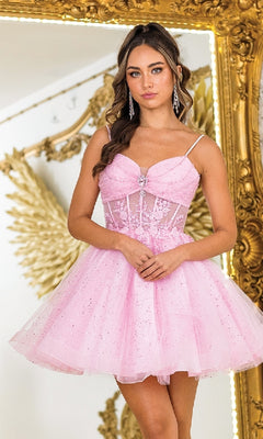 Woman wearing a pink dress standing in front of a decorative mirror.