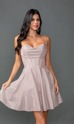 A woman stands against a gray background wearing the Dancing Queen 3421 short prom dress—light pink, sleeveless, with a glitter finish, fitted corset bodice, and flared skirt.