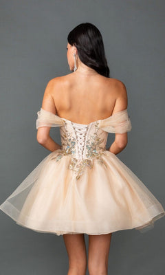 A woman stands facing away, wearing the Dancing Queen 3423 short prom dress in light beige, featuring an off-the-shoulder design, lace-up back, floral embroidery, and an elegant A-line skirt.