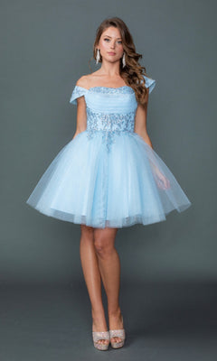 A woman wearing the Dancing Queen 3433 short homecoming dress in Bahama Blue, an off-shoulder knee-length tulle design with an embroidered corset bodice and delicate lace detailing, paired with silver earrings and glittery peep-toe heels, standing against a plain gray background.