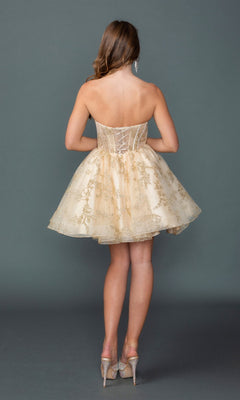 A woman stands facing away against a plain gray background, wearing the Short Homecoming Dress: Dancing Queen 3436, which features a strapless sweetheart neckline, gold embroidery, and sparkly high heels.