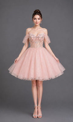 A woman stands against a gray background wearing the Dancing Queen 3438 short homecoming dress in pink, featuring off-the-shoulder straps, a fitted embellished bodice, and a sparkly tulle skirt, paired with strappy silver heels.