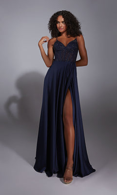 A woman poses in the Aerie Couture 348, a long navy blue A-line prom dress with a rhinestone corset bodice, spaghetti straps, and a high slit, against a plain gray background.