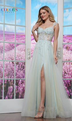 A woman in the Off-Shoulder Glitter Tulle Prom Ball Gown: Colors Dress 3498 stands before glass doors, her thigh-high slit and corset bodice with floral details capturing elegance amid a field of purple flowers.