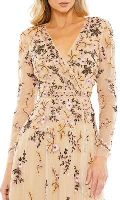 A woman wears the Mac Duggal Midi Floral Wedding Guest Dress in beige, featuring long sleeves, a fitted waist, a V-neckline, and pink, purple, and gold floral embroidery.