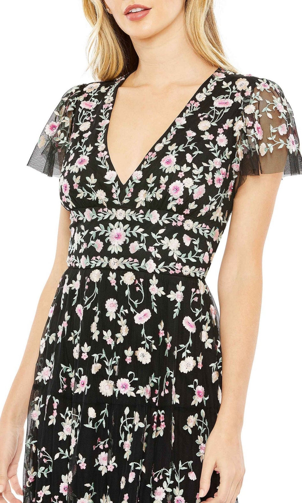 Woman wearing the Embroidered Wedding-Guest Dress: Mac Duggal 35104, featuring a v-neck, short sheer sleeves, and pink and white floral embroidery.