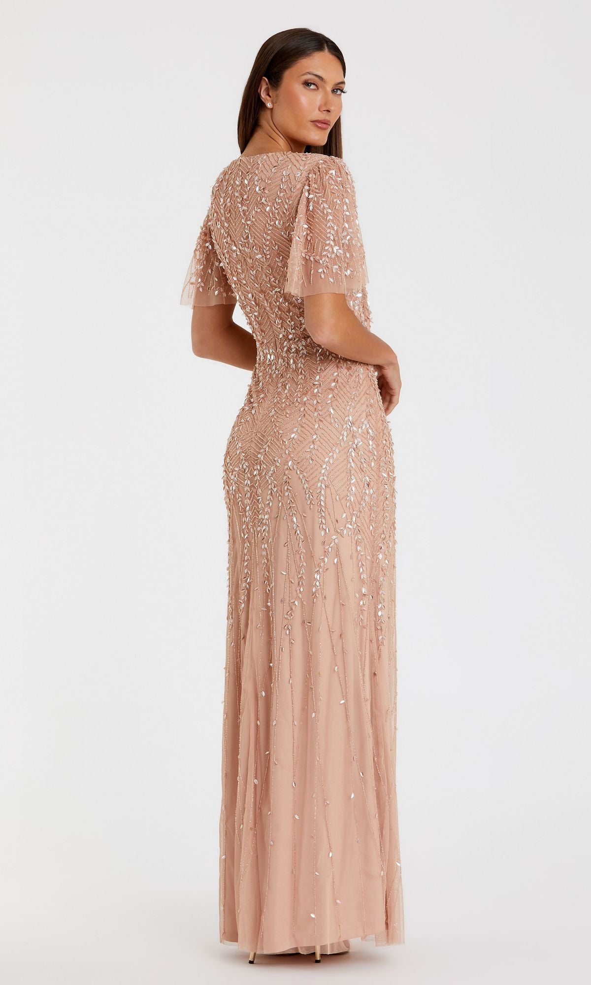 A woman models the floor-length Flutter-Sleeve Long Formal Dress (Mac Duggal 35109) in light pink, standing with her back turned and head facing the camera against a plain white background.