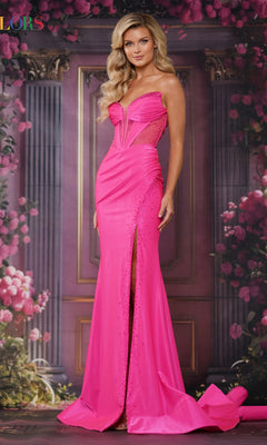 A woman in the Sheer-Waist Long Prom Dress: Colors Dress 3562, a bright pink strapless gown with a thigh-high slit, stands before a backdrop of flowers and columns.