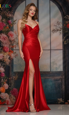 A woman wearing the Long Classic Lace-Up Prom Dress: Colors Dress 3602, a fitted red satin gown with a thigh-high slit, stands before a floral and arched window backdrop.