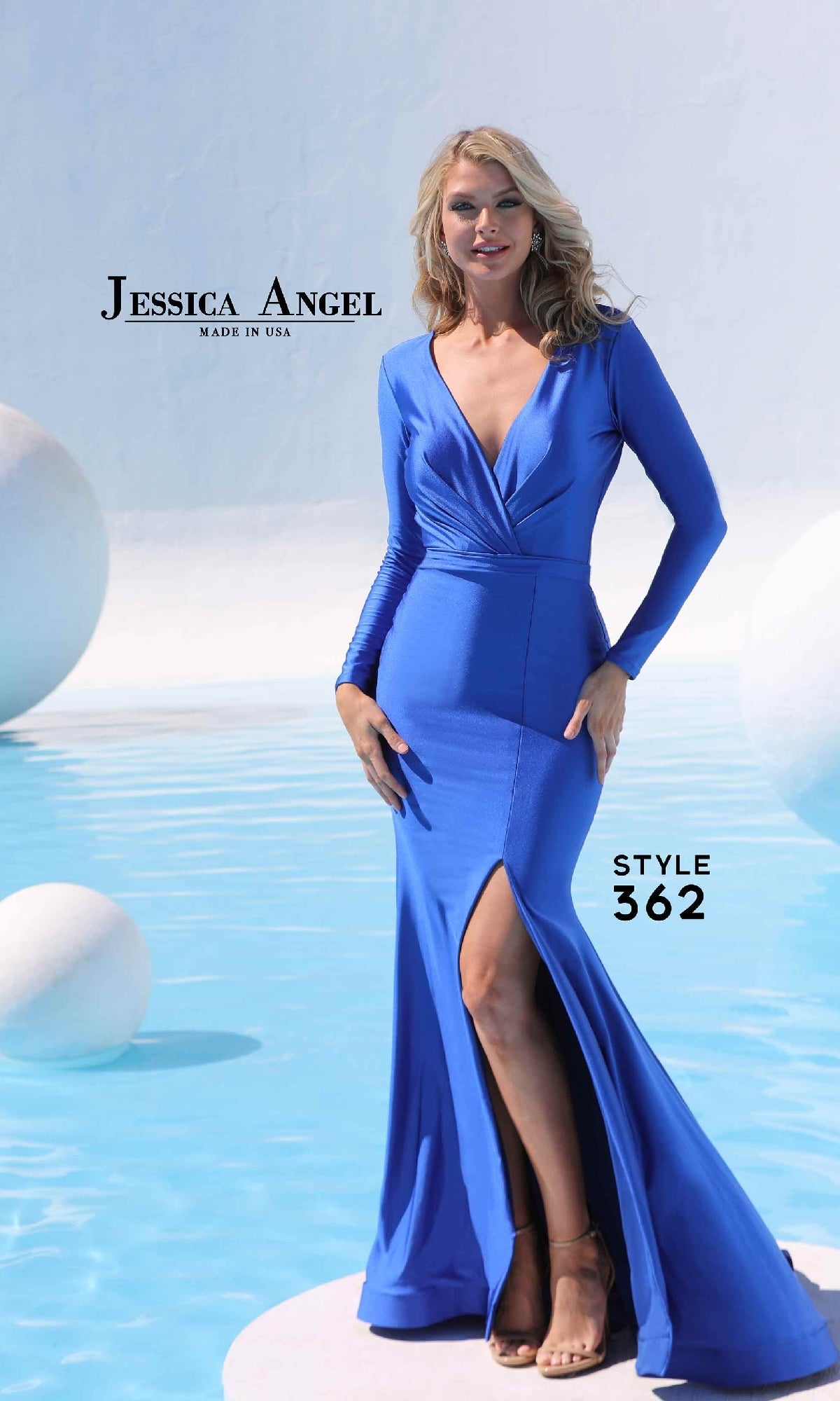 A woman stands by a pool wearing the Jessica Angel 362 long sleeve formal dress in blue, featuring a front slit and mermaid skirt. The image displays 