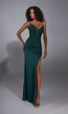 A woman wears the Aerie Couture 362 long prom dress in dark green satin chiffon, featuring a fitted lace bodice, spaghetti straps, and a thigh-high slit, standing against a plain gray background.