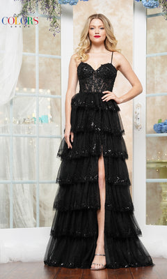 A woman poses indoors in front of tall windows, wearing the Sequin Prom Ball Gown: Colors Dress 3635—with a sleeveless black design, embroidered corset bodice, and sequin ball-gown skirt.