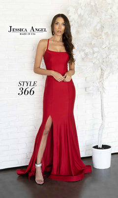 Woman wearing the Jessica Angel 366 Lace-Up Long Prom Dress—red, sleeveless, with an open back and high slit—stands indoors beside a white artificial tree.