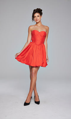 A woman stands against a plain light background wearing the Jovani Strapless Short Ruffled Hoco Dress 36620 in red, paired with black heels.