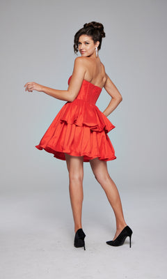 A woman models the Jovani Strapless Short Ruffled Hoco Dress 36620 with black high heels, posing against a plain light background and looking over her shoulder.
