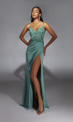 A woman stands against a gray background wearing the Long Sage Green Prom Dress: Aerie Couture 369, featuring a thigh-high slit, sheer beaded bodice, and thin straps.