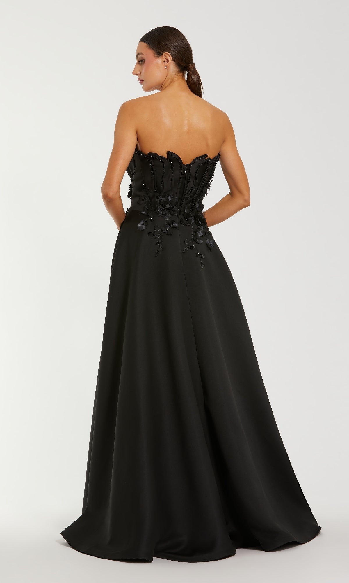 Black strapless gown with floral details on a white background