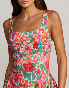 A woman wearing the Floral Midi Wedding Guest Dress: Mac Duggal 37155, a sleeveless crepe midi dress featuring a square neckline and a bright, colorful floral pattern—perfect for weddings.