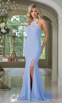A woman wearing the Bead-Trimmed Halter Prom Gown: Colors Dress 3718 in cornflower stands indoors near a decorative table and floral arrangement.