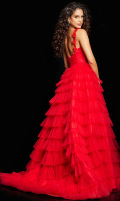 A woman with long, curly hair wears Jovani's Long Prom Dress 37274, featuring tiered tulle and a dramatic train. She stands against a black background, looking over her shoulder in the bright red gown.